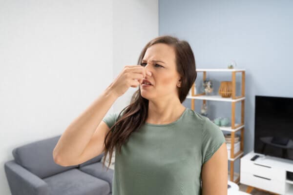 woman plugging nose from mold odor